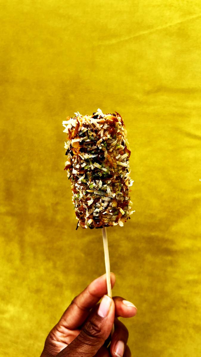 Left: Jerk and toasted coconut corn on a stick: roasted corn, jerk mayo and toasted coconut.  