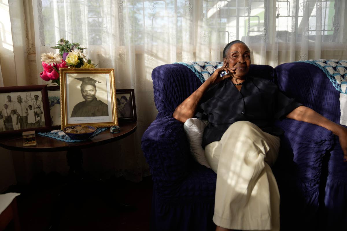Widow Marie Owino, 87 years old, a former teacher sits inside her home.