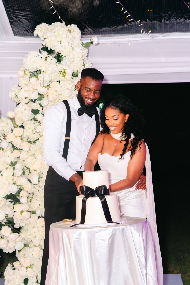 The Morgans share a sweet moment as they cut into their red velvet cake with cream cheese frosting, crafted by Shantelle Staple of Speciality Bakes.