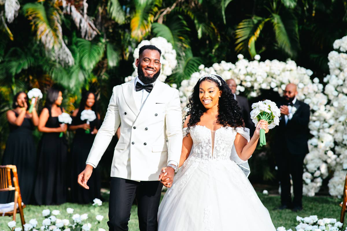 The newlyweds beam with joy as they make their first walk up the aisle together.