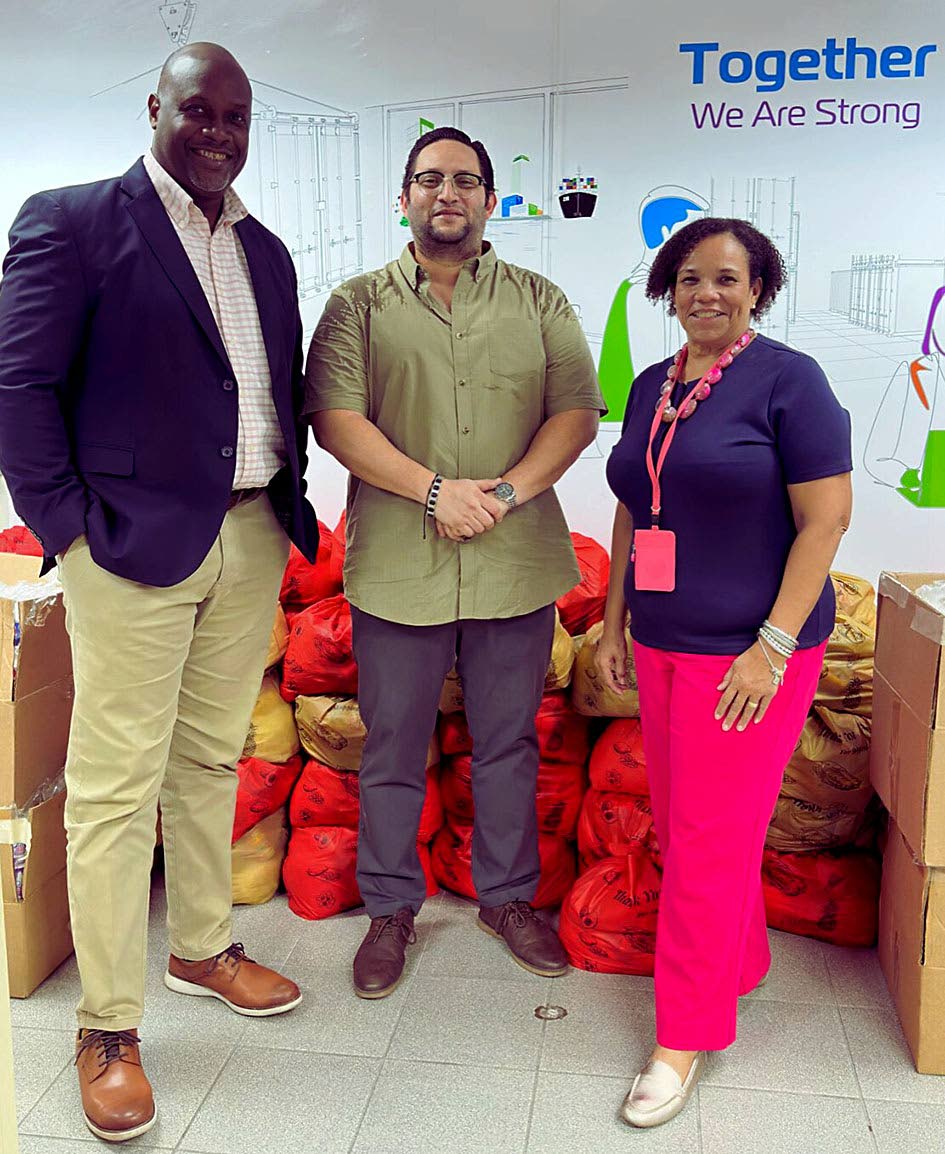 Corah Ann Robertson-Sylvester, president, SAJ, and Terrence Brooks, GM, SAJ, receive care packages from Carlos A. Murillo C., GM, ZIM–Carib Star (centre).