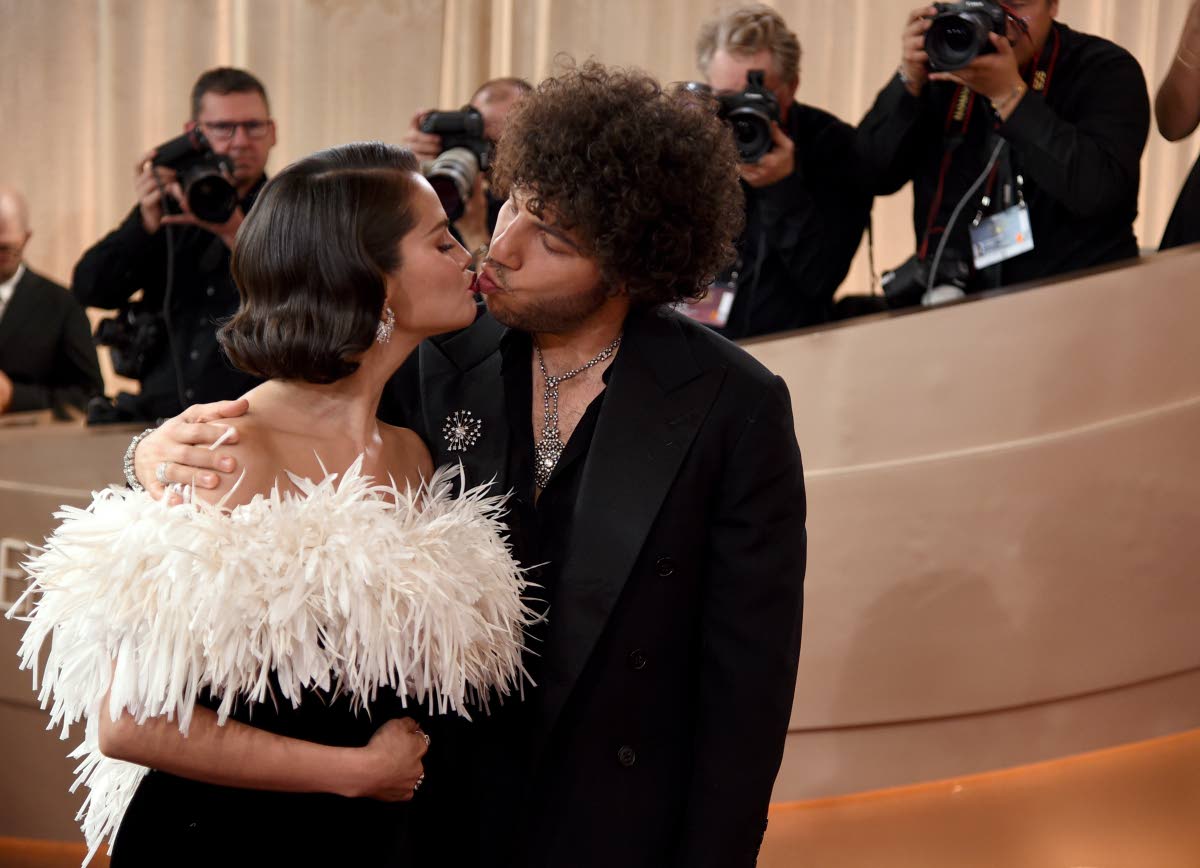 Newlyweds Selena Gomez and Benny Blanco share a kiss on the Golden Globes carpet, with Gomez stunning in a custom Chanel gown and Chanel High Jewelry.