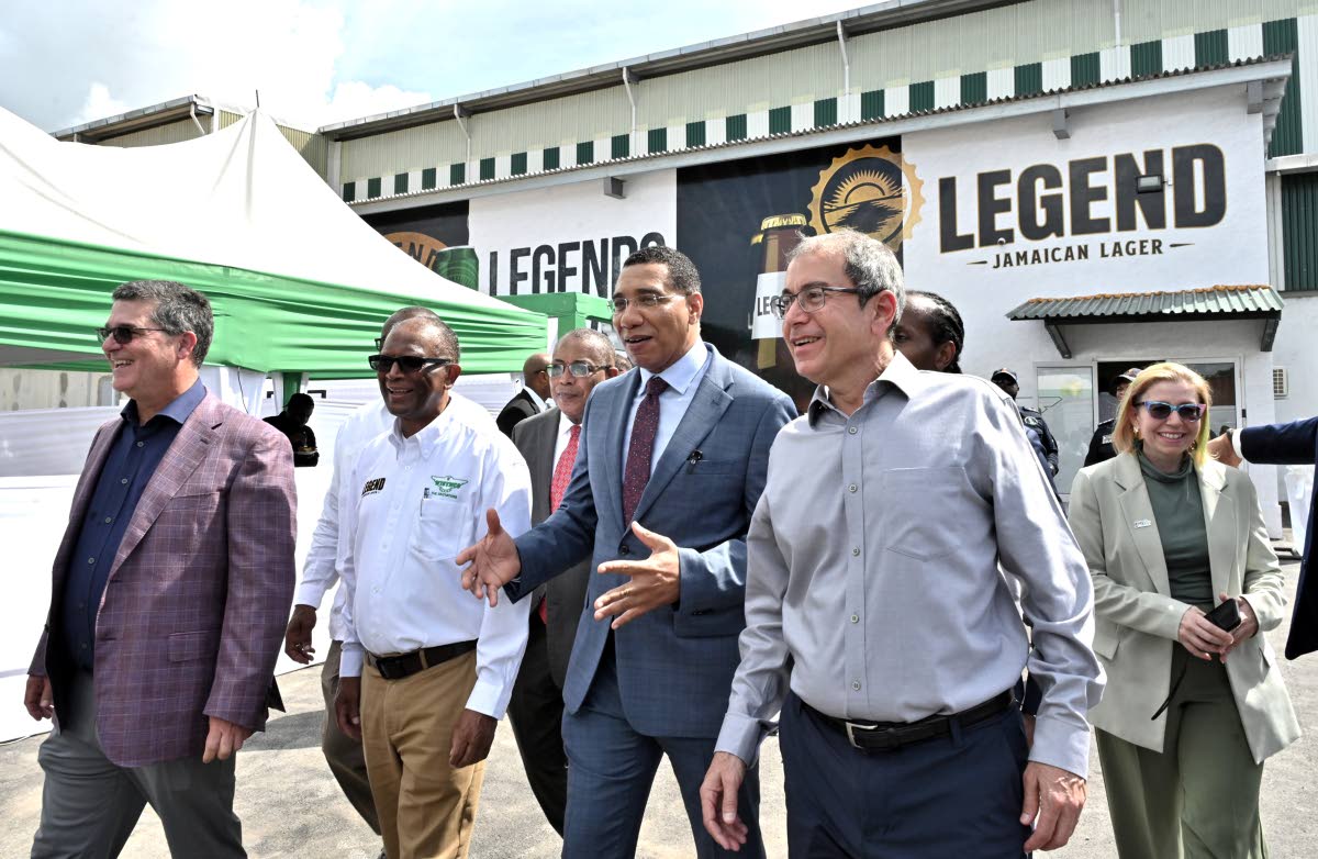 Prime Minister Dr Andrew Holness (centre) makes a point on a tour with William Mahfood (left), chairman of Wisynco Group; Devon Reynolds, director of manufacturing; Anthony Hylton, opposition spokesperson on industry, investment and logistics; Andrew Mahfo