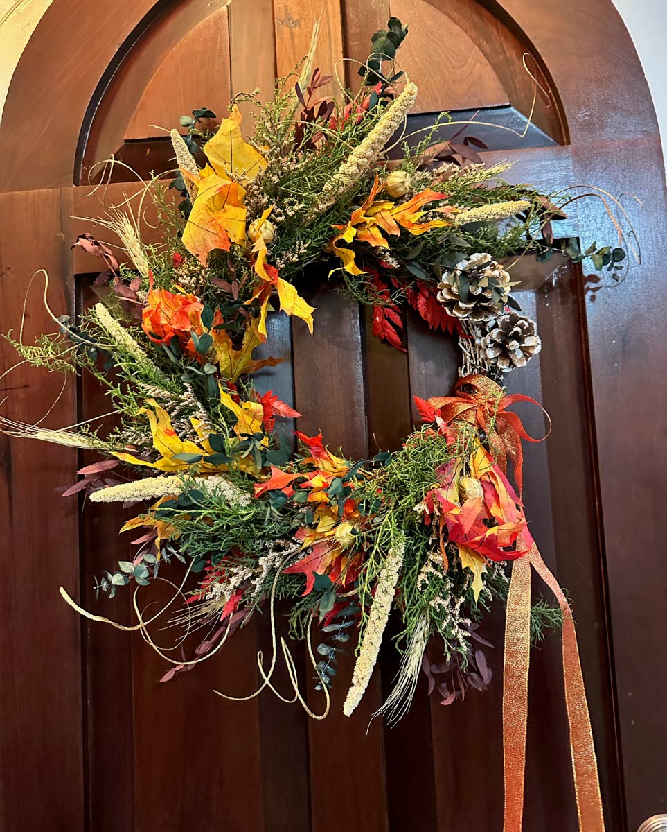 Christmas wreath by Boho Botanics, crafted with fragrant local evergreens, sun‑dried millet, preserved oak and eucalyptus, and finished with pine cone accents.