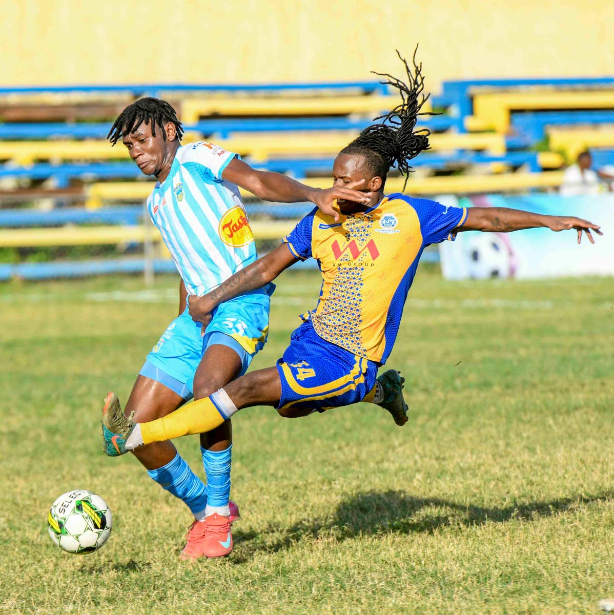 Harbour View’s Alonzo Peart (right) throws himself into a tackle against Waterhouse’s Kvist Paul during a Jamaica Premier League fixture at the Harbour View Mini-Stadium in Kingston yesterday. The game ended 1-1.