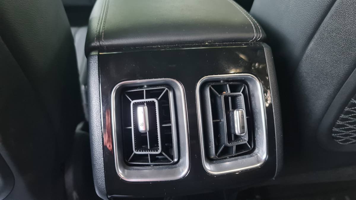 Practical consideration for second-row passengers, showing the dedicated air vents and charging ports for maintaining comfort on longer journeys.