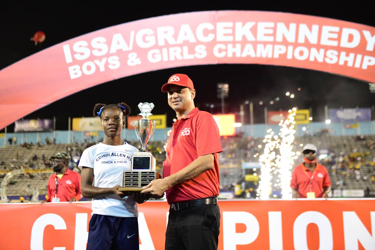 Edwin Allen’s Leanna Lewis (left) accepts the Girls’ Championship trophy presented by Don Wehby, group chief executive officer, GraceKennedy Group in 2022.