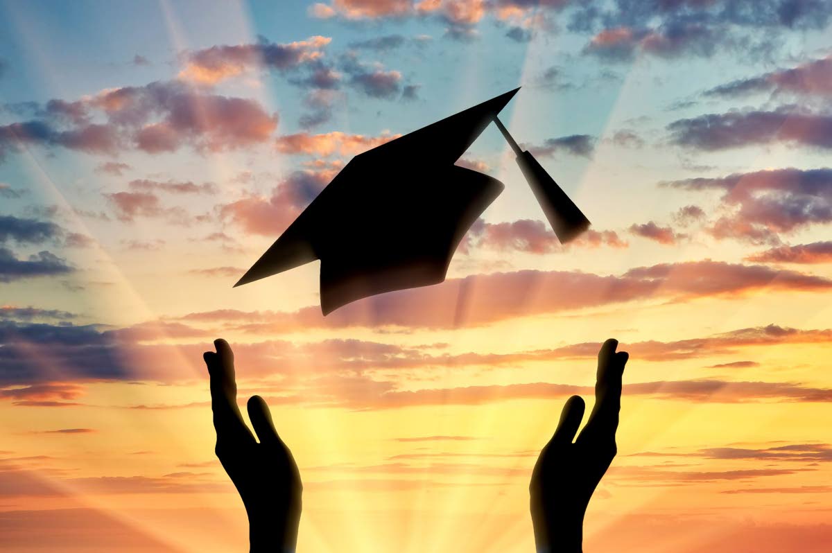 Hands graduate cap throw up into sky sunset