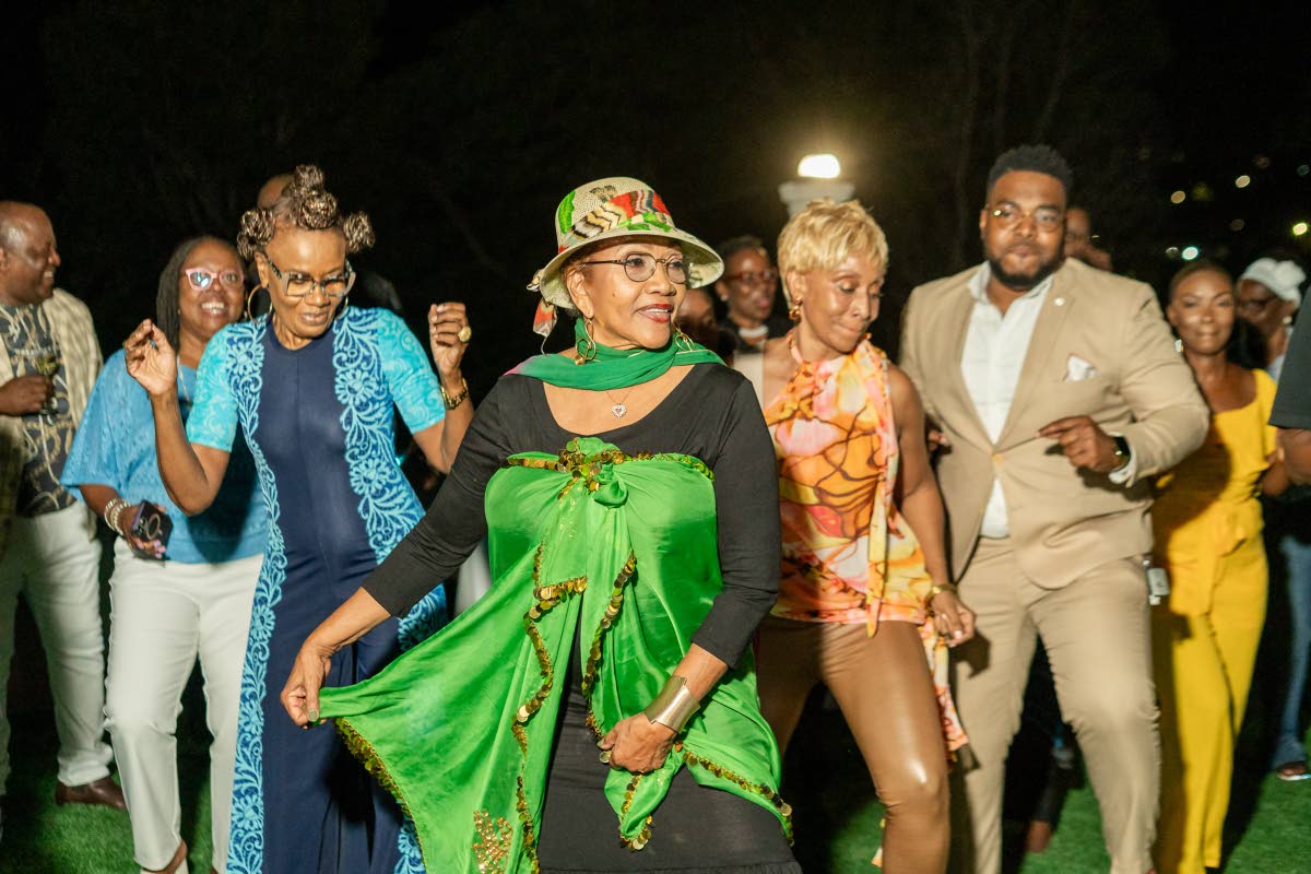 Dr Marcia Griffiths (front centre) shares a light-hearted moment with specially invited guests as they break into her global hit, the Electric Boogie, during the post-graduation reception at her residence on Saturday.
