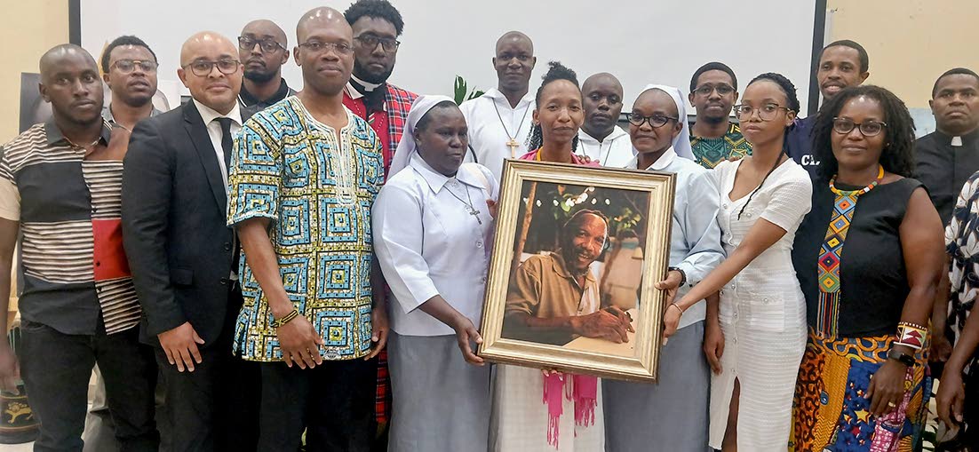 Meloddi Mazola holds a framed photograph of the late artist Mazola, surrounded by Kenyan compatriots in Jamaica. Second from left is Dr Kevin Brown, president of the University of Technology, Jamaica.
