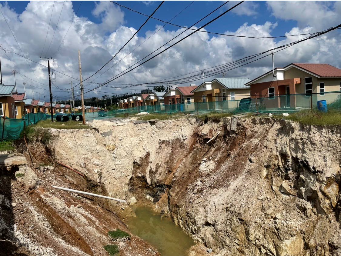 The deep pit initially caused by lands caving in at Estuary Housing Scheme in St James.