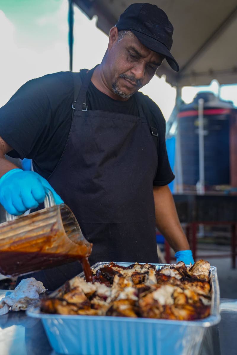 Chef Donald Pallas adds rich jerk sauce over fresh chicken in the packing section of the Negril Field Kitchen, locking in the smoky spice that defines this iconic dish. “The sauce rounds it all out,” he says. “That’s what makes it finger-licking go