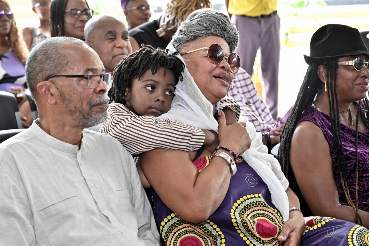 Jahseh, (second left) son of singer Samory I hugs Bridgett Anderson, (second right) mother of Ricardo Anthony Munoz Bennett, while father Ricardo Munoz Bennett looks on.