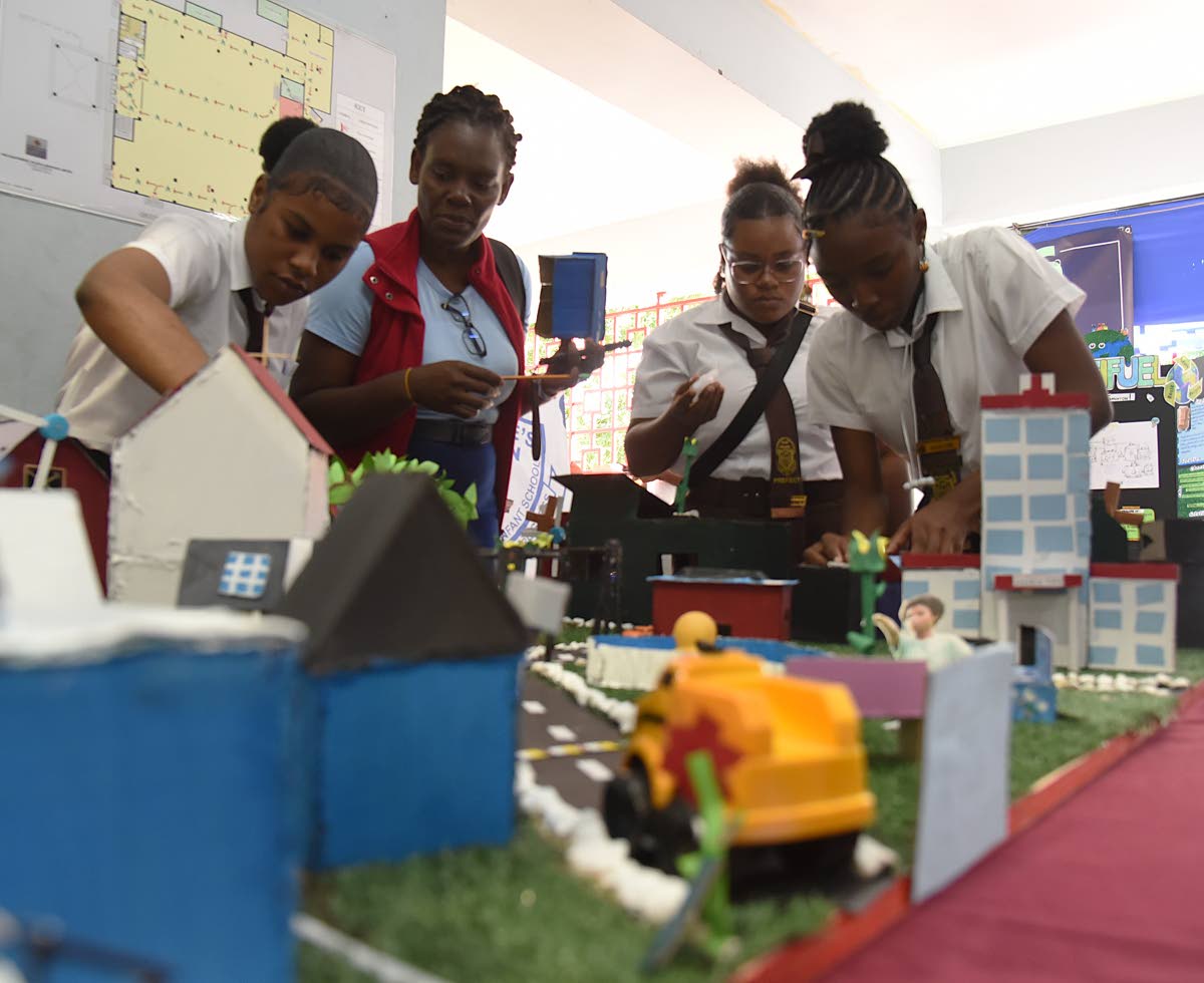 Students from Holmwood Technical High School organise their exhibit just before the start of the STEAM in Action Expo, which was held at the Chinese Benevolent Association in St Andrew last Thursday.