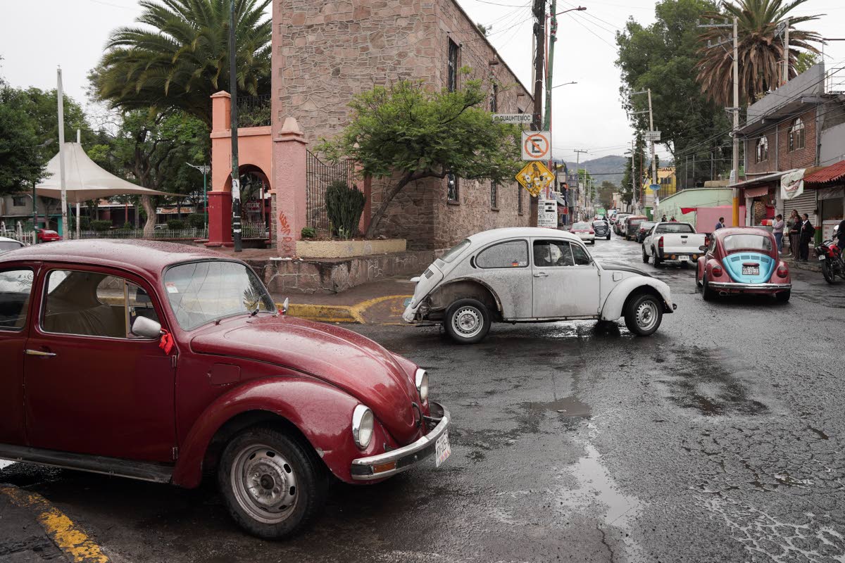 Volkswagen Beetles circulate offering taxi service in the hilly Cuautepec neighbourhood of Mexico City.