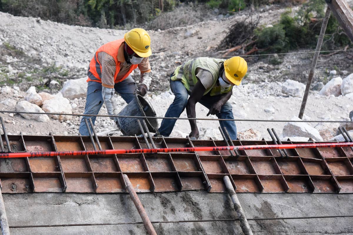 An employee of China Harbour Engineering Company Ltd (CHEC) constructs a retaining wall along the St Thomas main road in the vicinity of the Grants Pen community in 2020.
