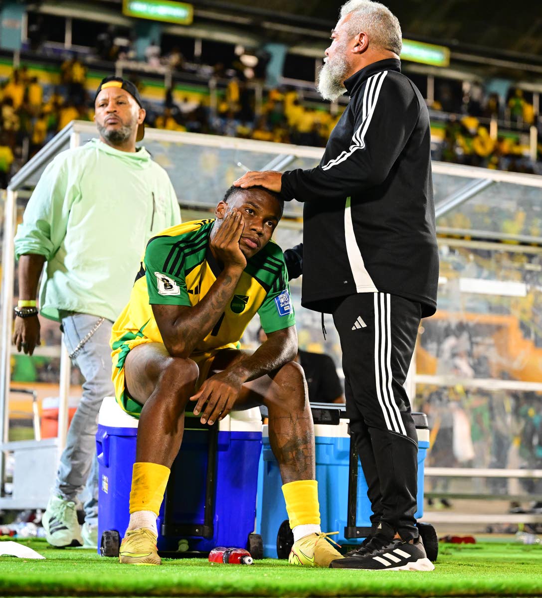 Craig Butler (right) consoles a dejected Dujuan Richards moments after a 0-0 draw against Curacao at the National Stadium on November 18, 2025 left the Reggae Boyz short of automatic qualification to the FIFA World Cup. 
