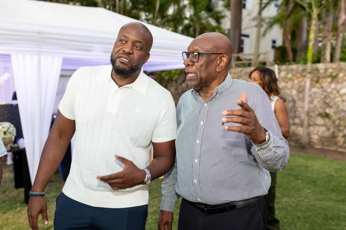 Father and son, Elon Beckford (right), and Wayne Beckford, general manager, Treasury, JMMB Bank, share in meaningful conversation.