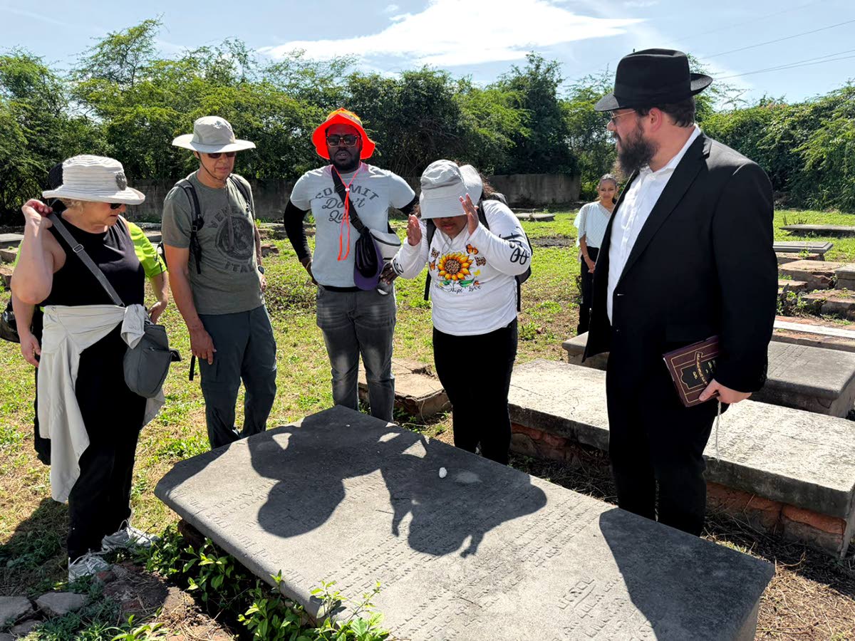  
A group gathers at the burial site of Jamaica’s first Rabbi, Yoshiyahu (Josiah) ben David Pardo.