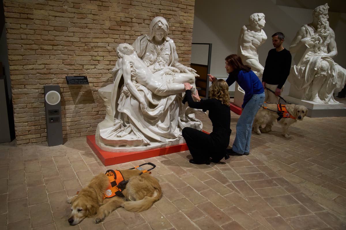 Stefania Terre, left, touches a reproduction of Michelangelo’s sculpture La Pieta with Carmine Laezza, standing at right, during a tour for blind people with Monica Bernacchia, centre, at the Omero Tactile Museum in Ancona, Italy.