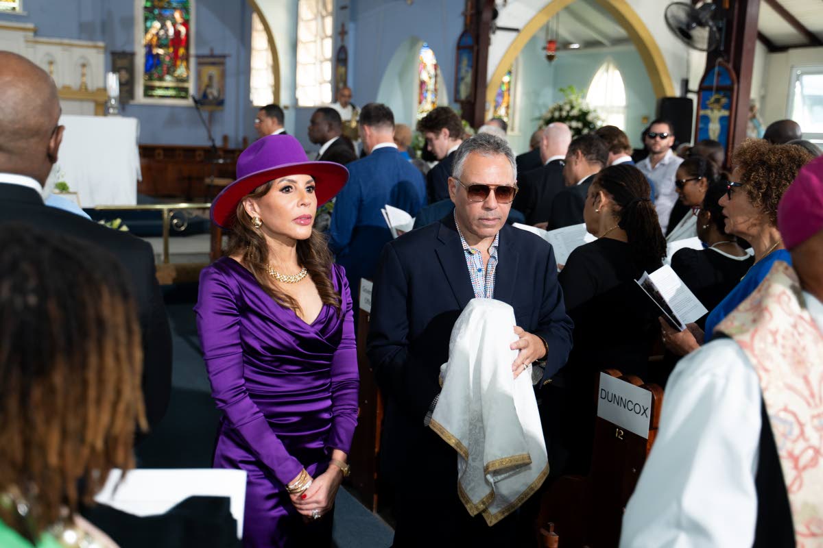 Paula Kerr-Jarrett Wegman and her brother Peter Bovell carry the urn with their father Christopher Bovell's ashes during the funeral. 