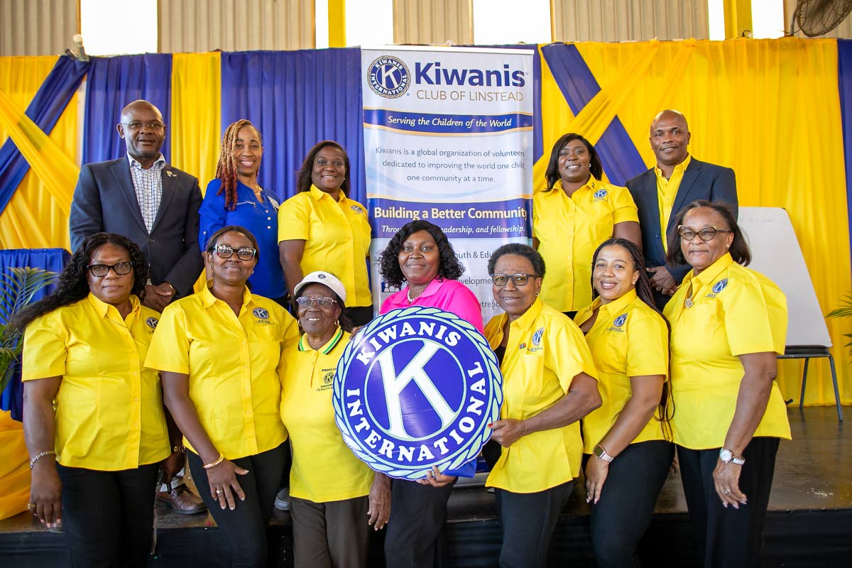 President Marlon Stephens (top row, far right) stands with Lieutenant Governors Dione Chambers (top row, second right) and Michael Powell (far right), joined by members of the Kiwanis Club of Linstead. 