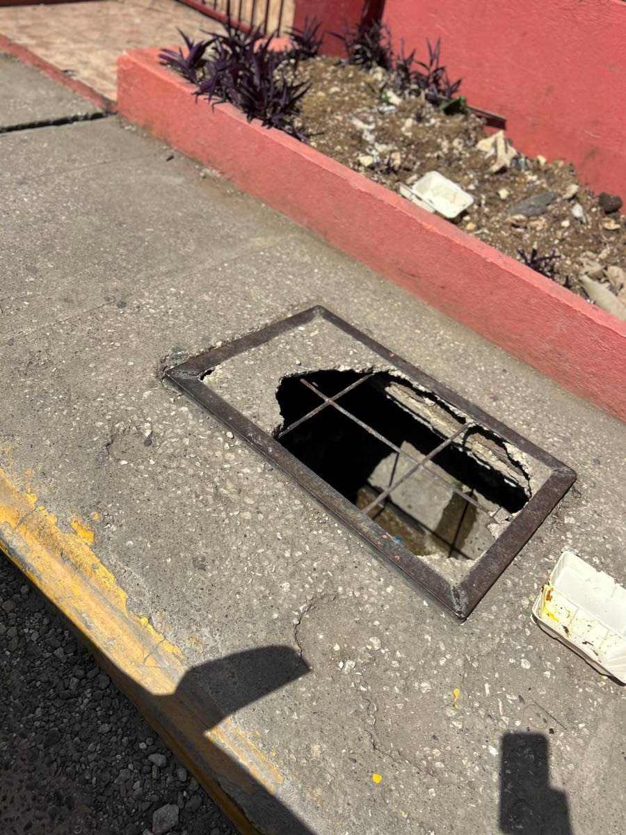 The open hole along Lewis Street in Savanna-la-Mar, Westmoreland, where a young girl fell after jumping aside to avoid an oncoming vehicle.