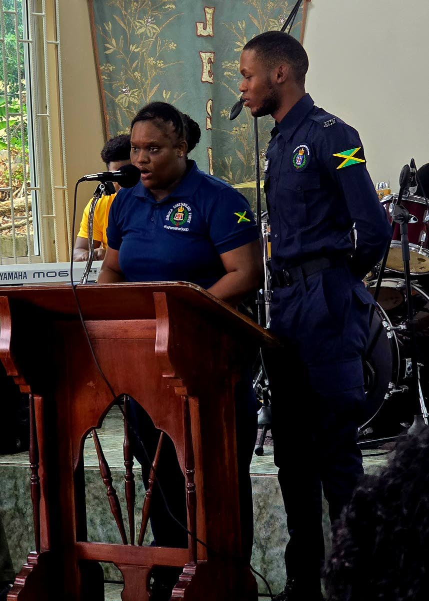 Two members of the Jamaica Constabulary Force stationed in Duncans, Trelawny, entertain members of the congregation during the More FM 14th anniversary celebrations. 