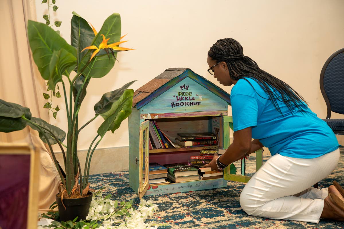 A patron adding books to the My Free Likkle Bookhut.