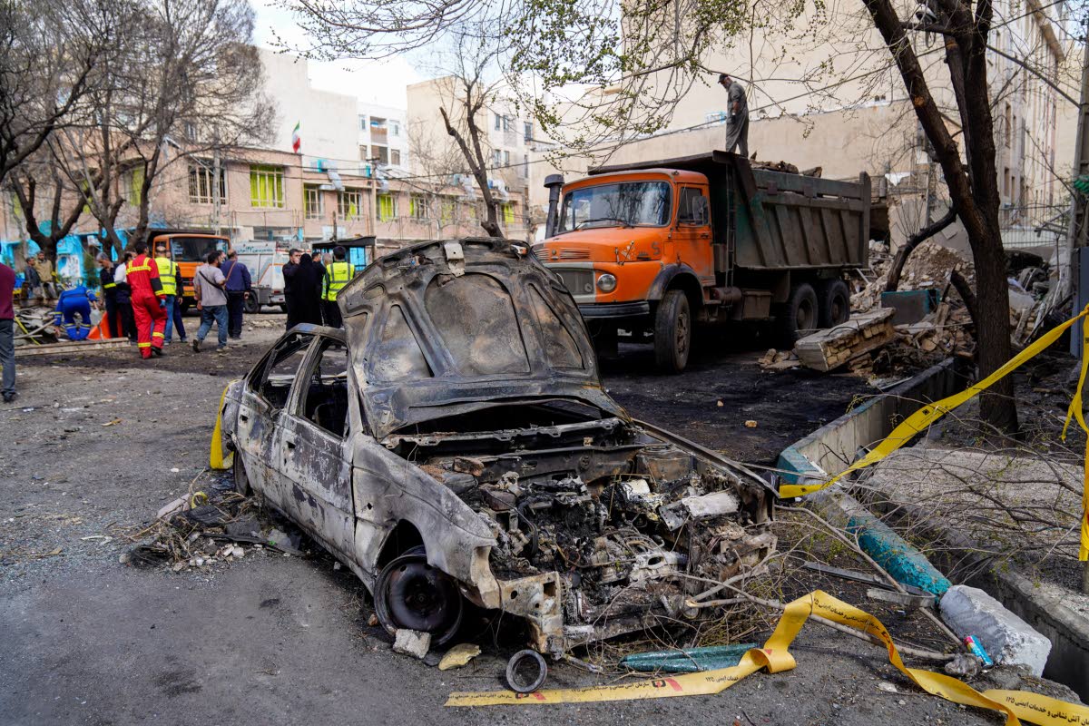 A damaged car remains on the ground in the aftermath of an Israeli-US strike in Tehran.