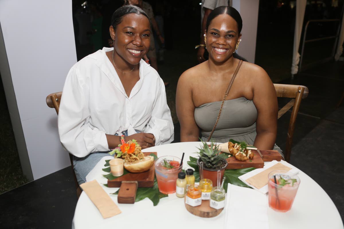 Stacy Salmon (right) and Tashara-Lee Johnson are ready to indulge in Stush in the Bush’s beet and feta burger, with cho-cho fries and eggplant and okra fish steak on Saturday at the Lost in Time music festival. 