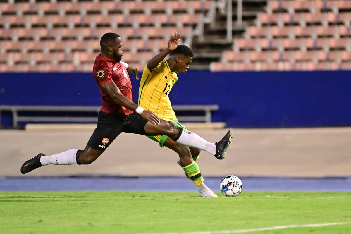 Jamaica’s Dujaun Richards (right) is tackled by Trinidad and Tobago’s defender Josiah Trimmingham during a friendly match at the National Stadium on Tuesday, March 14, 2023.