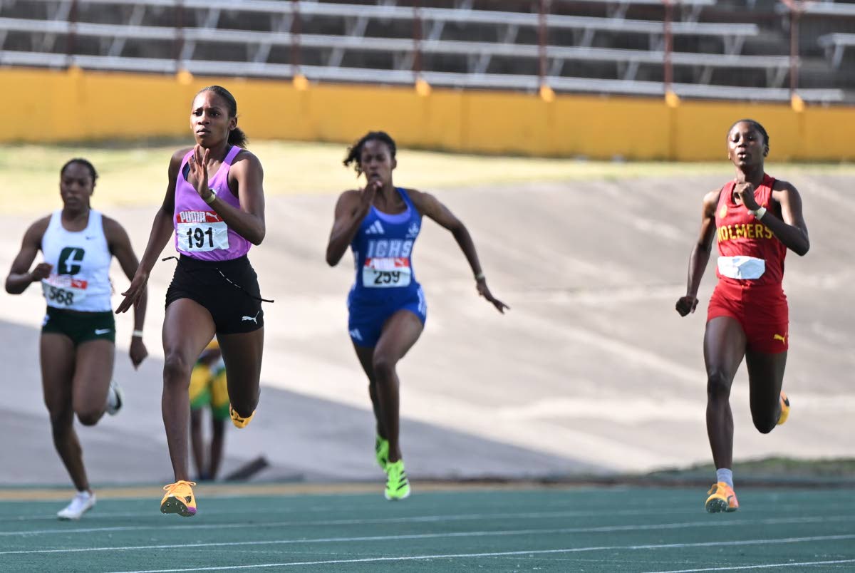 Holland High’s  Shanoya Douglas (second left) wins the under-20 girls 200 metres in  a personal-best 22.58 seconds on the final day of the Carifta Trials  at the National Stadium yesterday. 
