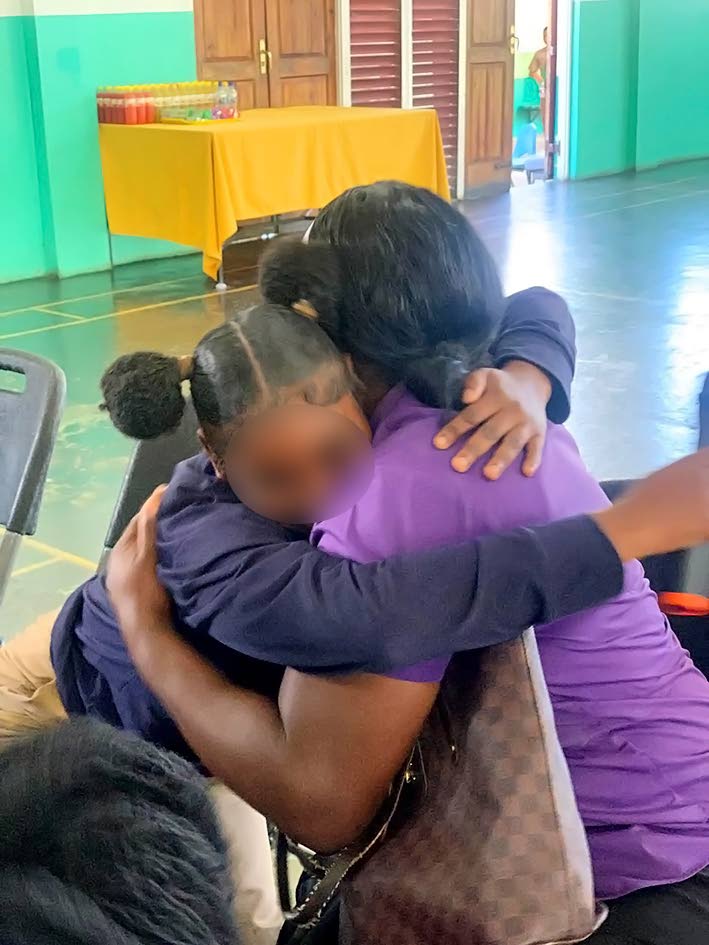 A student of Bel Air High School hugs her guardian. 