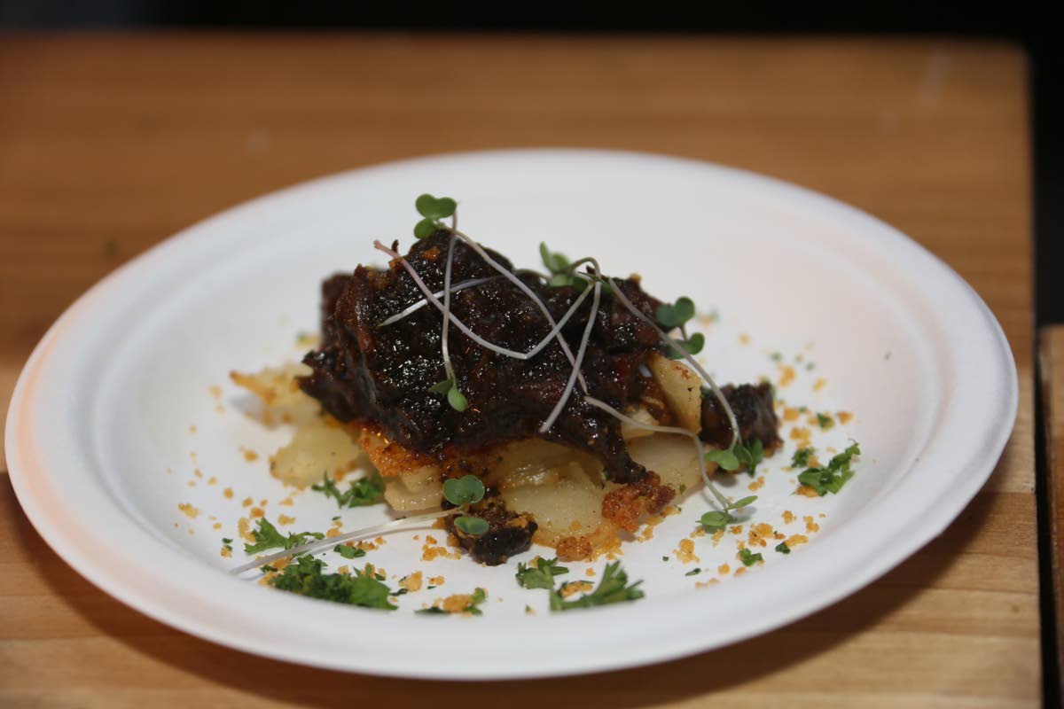 Chef Scotley Innis’ oxtail pavé, a slow-braised oxtail, layered with cassava and finished with potato foam and smoked parmesan for a refined take on the Jamaican classic.