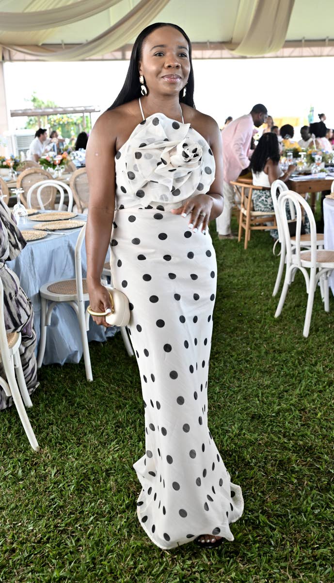 Sashalee Miller, senior manager of sales, loyalty, and product development at First Global Bank, adds a touch of flair with a black and beige polka-dot dress punctuated by a striking floral detail.
