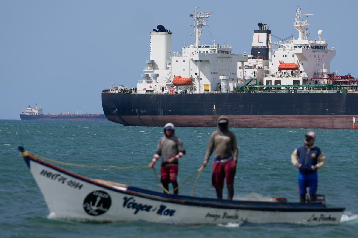 Fishermen pass an oil tanker in the Gulf of Venezuela off the shore of Punta Cardon, Venezuela.