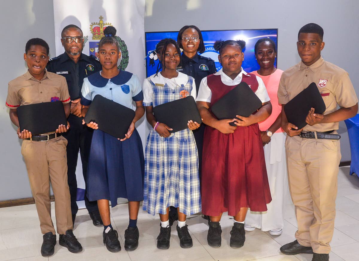 Left: Sheldon Walters, Britany Thompson, Elizabeth Cunningham, Ashley Jones, and Justine Stone, students who recently received laptops. In the background (from left): Territorial Officer for the St Catherine North Police Division, Inspector Ishmael William