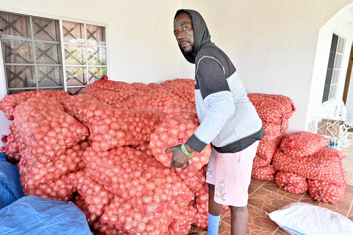 
Kevin Cooper, onion farmer in Heartease, St Thomas, with tons of onions stored on his aunt’s veranda.  