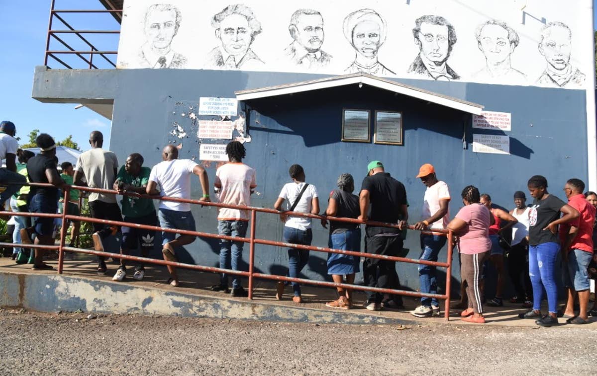 This file photo shows people waiting to exercise their franchise on election day.