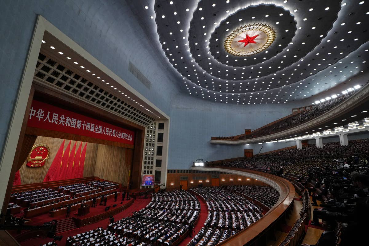 A screen shows Chinese President Xi Jinping as Premier Li Qiang delivering his work reports during the opening session of the National People’s Congress (NPC) at the Great Hall of the People, in Beijing.