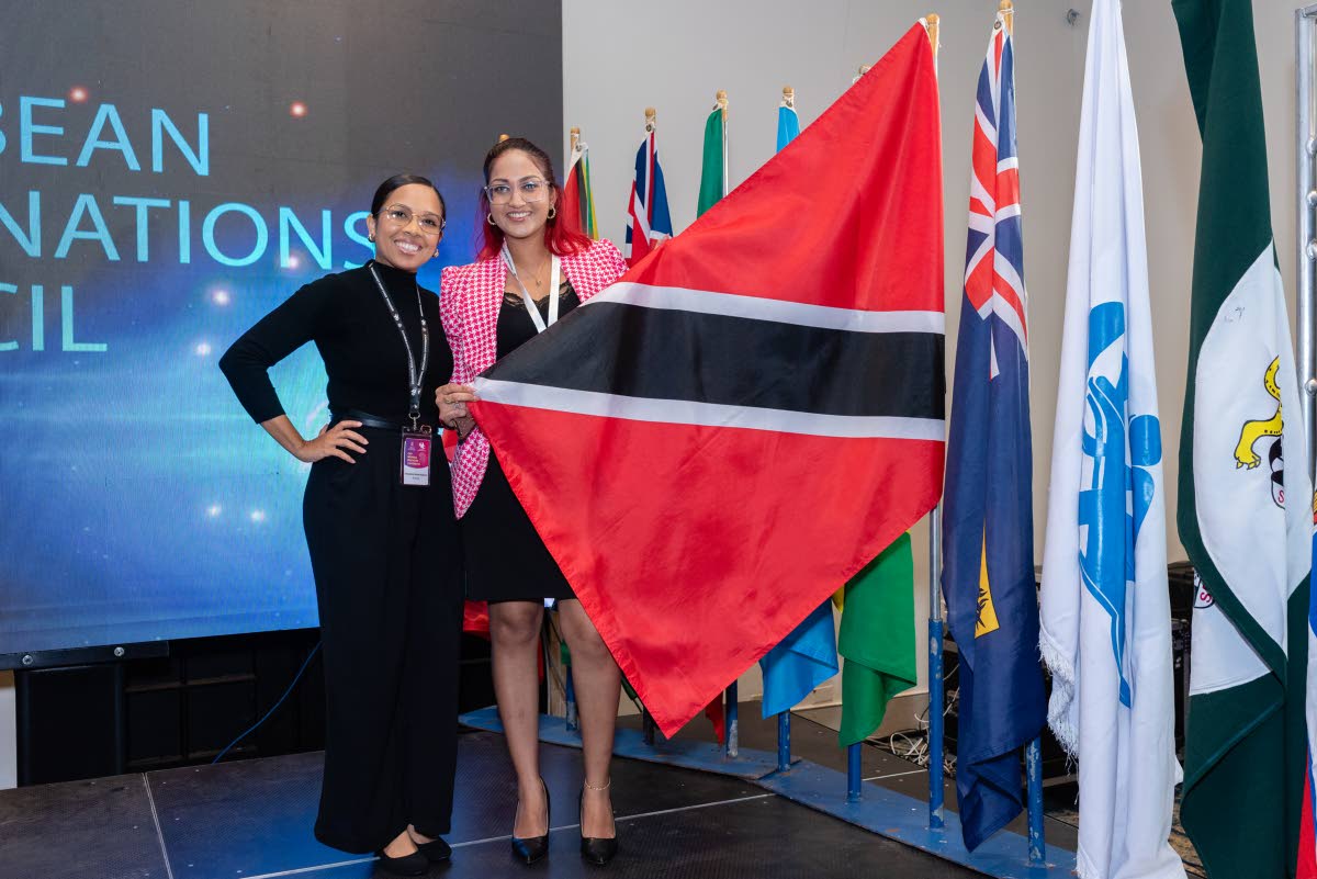 Tisheena Heath-Adams (left) and Leanna Samaroo, educators from Trinidad and Tobago, pose for a photo with their national flag.