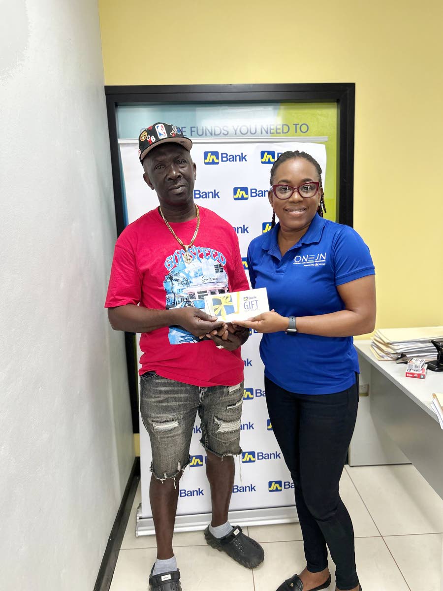 Roy Lamey accepts a grant from Marsha Salmon-Ebanks, client relations manager, JN Bank Small Business Loans Division, as part of the bank’s recovery efforts for small business operators affected by Hurricane Melissa.