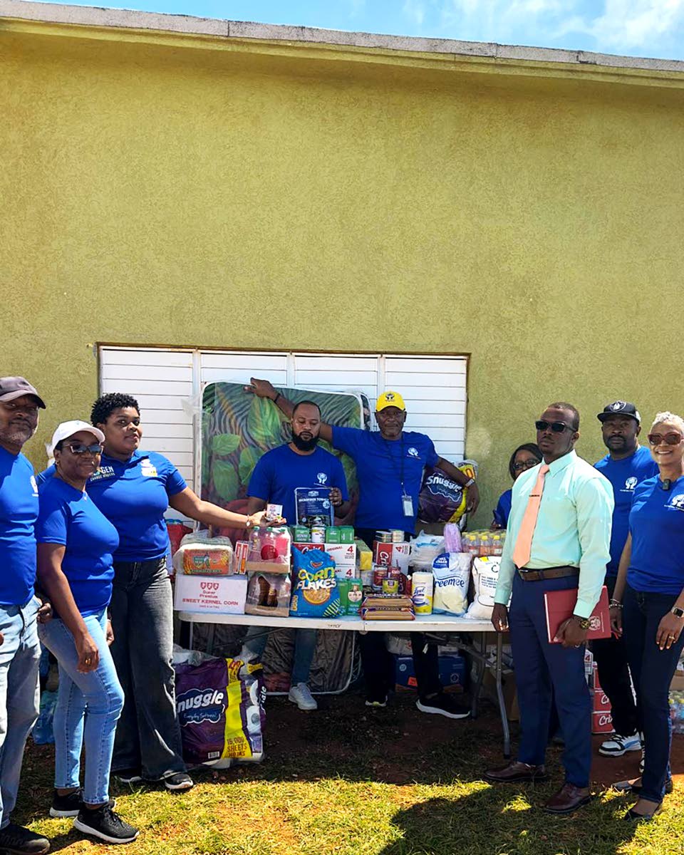 Credit union volunteers deliver goods from the 40-foot container to the home in Southfield. Manager Richard Aikens (far right) is pictured receiving the supplies on behalf of the boys.