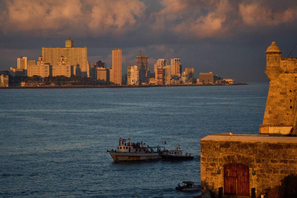 Activists wave Cuban and Palestinian flags from the vessel Maguro, arriving from Mexico with humanitarian aid as part of the "Nuestra America," or Our America Convoy, in Havana Bay, Cuba on March 24, 2026. (AP Photo/Ramon Espinosa)