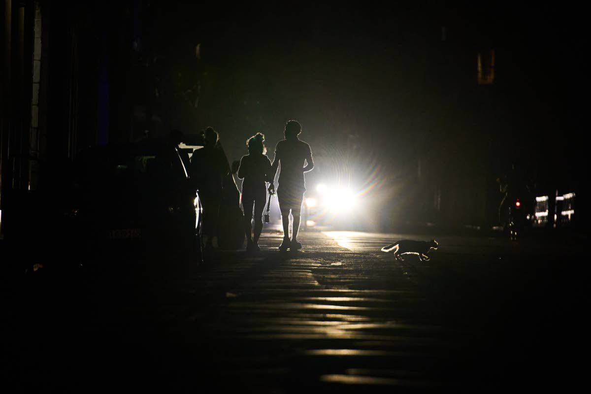 People walk on a street during a blackout in Havana, Cuba on March 21, 2026. (AP Photo/Ramon Espinosa)