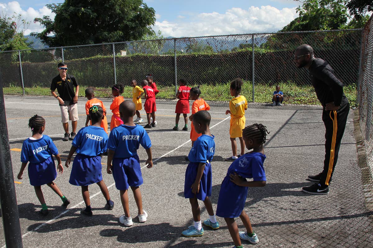 Akira Kanehama, Japan International Cooperation Agency (JICA) volunteer and Timol Stanberry, PE teacher, teaching a group of kindergarten students of Tarrant Primary School, to stretch. 