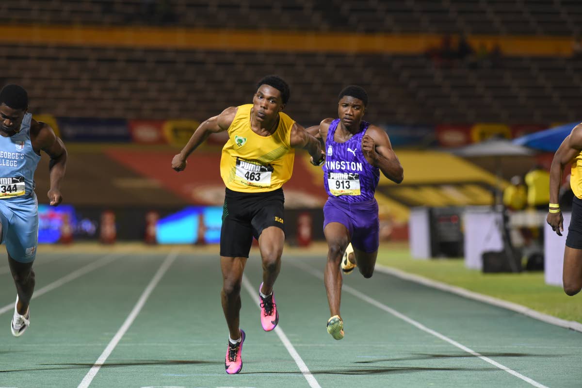 Excelsior High School’s Riquelme Reid dips at the tap to win the Class One boys’ 100m final at the ISSA/GraceKennedy Boys’ and Girls’ Athletics Championships at the National Stadium in Kingston on Wednesday night.