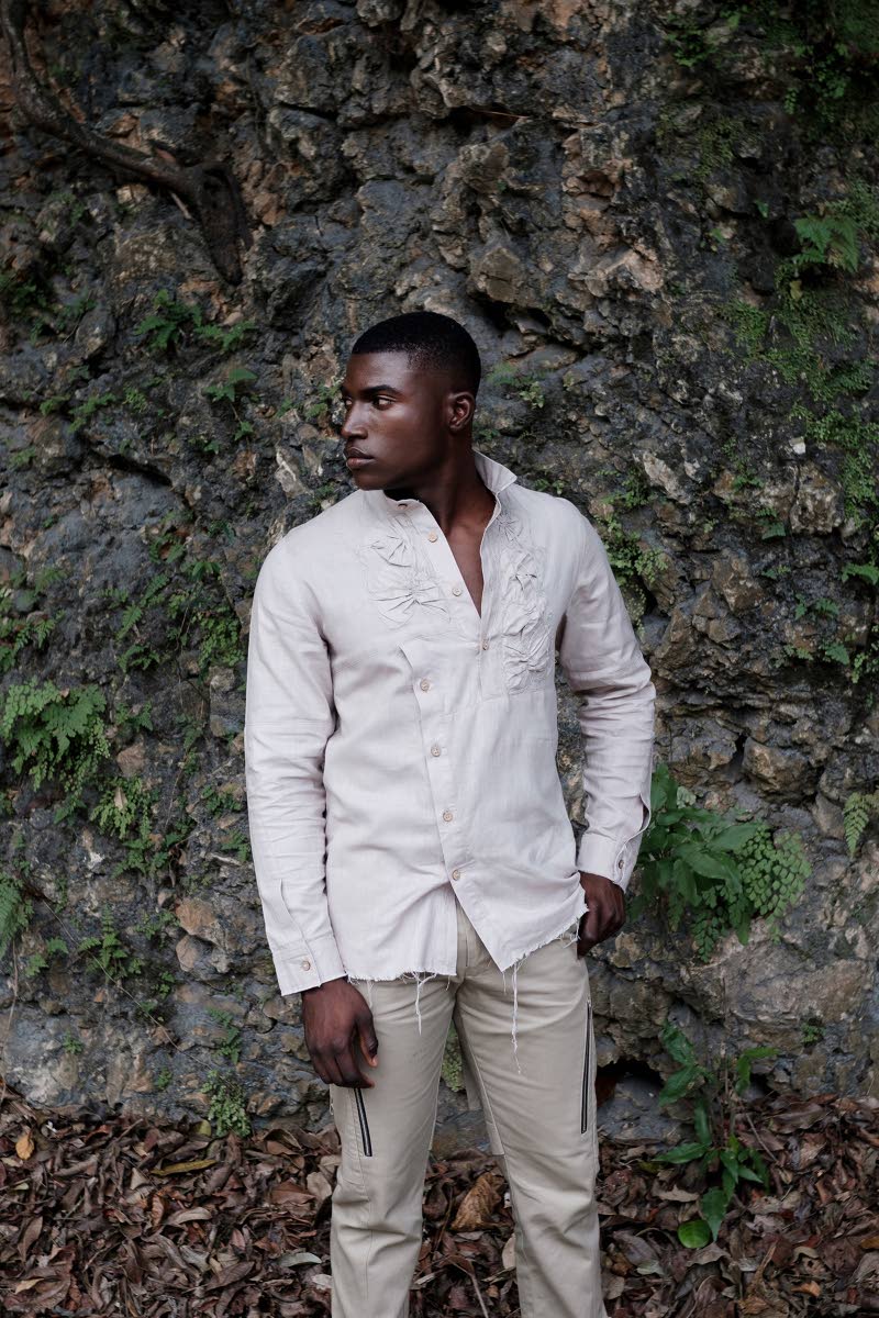 The stone grey erosion linen long sleeve shirt is presented with distressed rosette detailing and raw hems. It also highlights Howell’s signature mandarin collar and coconut shell button closure.