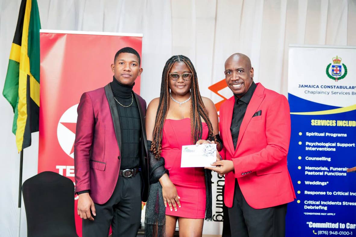 Constable Javaughn Young and Shy-Ann Monteith collect a gift certificate from Deputy Chaplain, Rev Dr Courtney Faulknor at the couple’s retreat. 